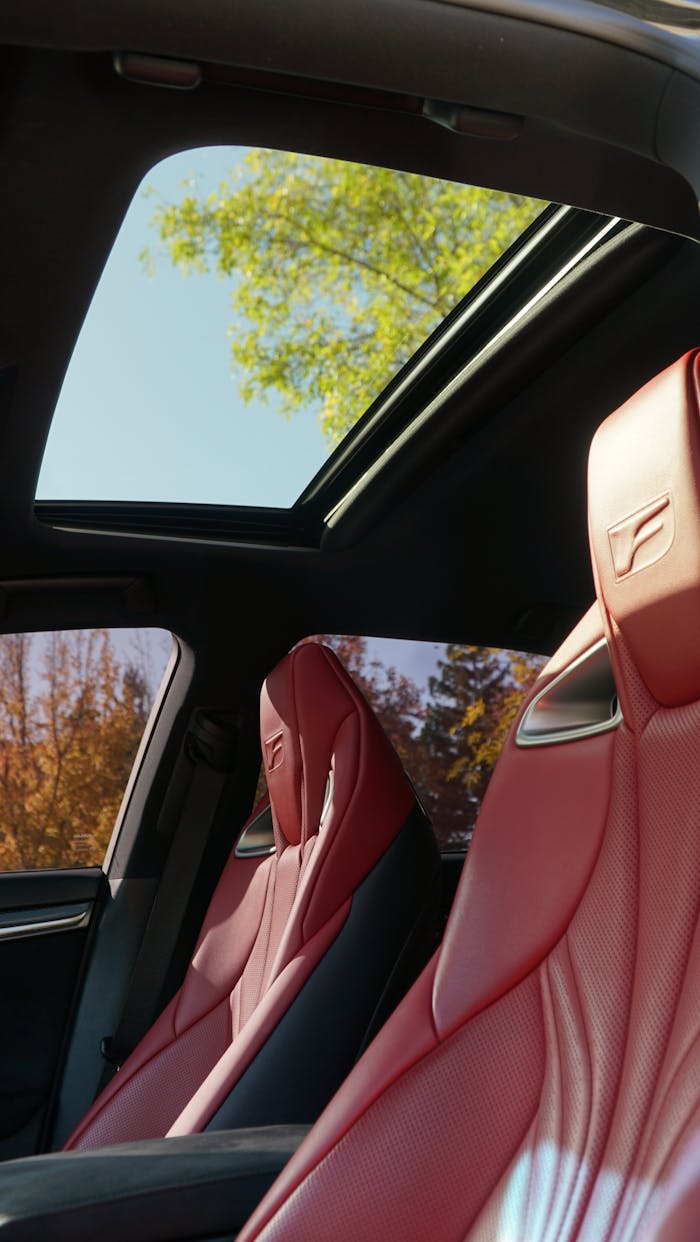 gallery-1 Red leather seats and open sunroof in a luxury convertible, showcasing elegance and style.