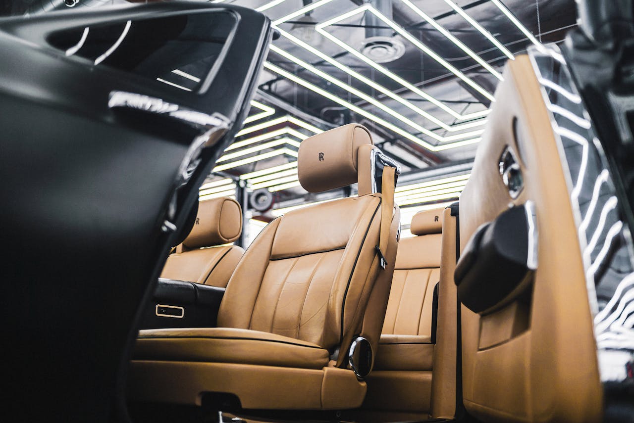 gallery-6 Elegant interior of a luxury car featuring tan leather seats and modern design elements.