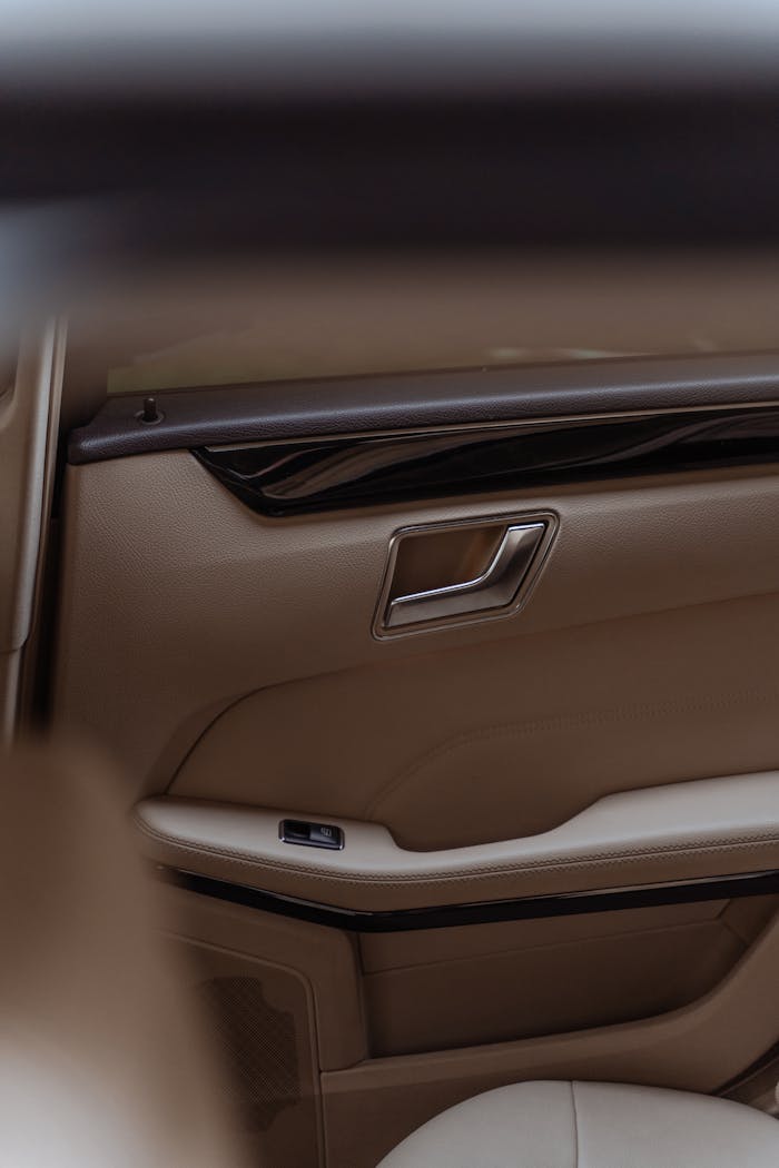why-choose-us Close-up of a modern tan leather car door interior with elegant design.